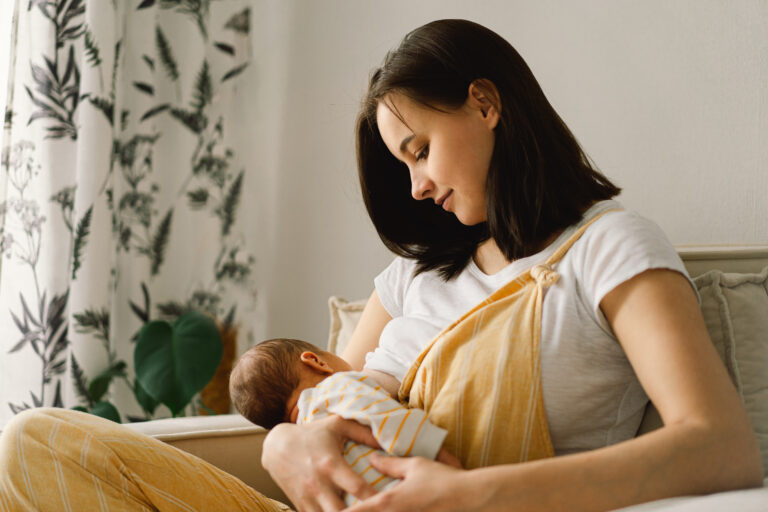 Portrait of mom and breastfeeding baby. Concept of healthy and natural baby breastfeeding nutrition.