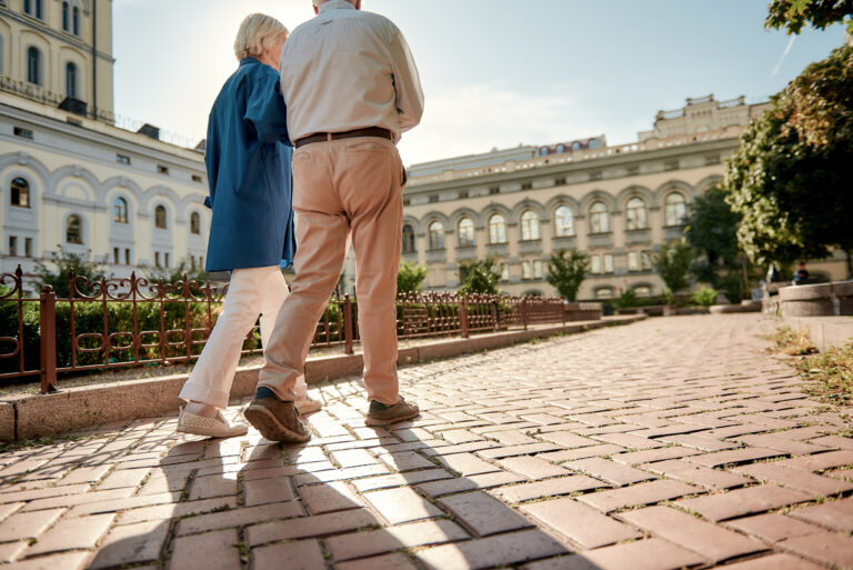 Traveling. Elderly stylish couple walking together outdoors. Family. Love concept