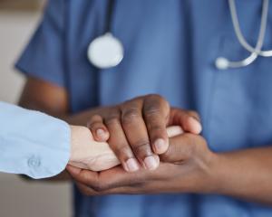 A physician holding a patients hand
